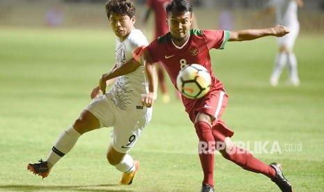 Pesepak bola Indonesia U-23 Muhammad Hargianto (kanan) berebut bola dengan pesepak bola Korsel U-23 Kim Hyeonug (kiri) dalam pertandingan ujicoba di Stadion Pakansari, Bogor, Sabtu (23/6). 