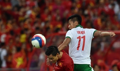  Pesepak bola Indonesia Yandi Sofyan Munawar (kanan) berebut bola dengan pesepak bola Vietnam Guyen Minh Tung dalam perebutan juara ketiga Sepak Bola Sea Games ke-28 di National Stadium, Singapura, Senin (15/6).(Antara/Wahyu Putro)