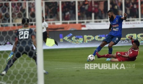 Pesepak bola klub Arema Malang Sylvano Comvalius (tengah) menendang bola dengan dikawal pesepak bola Persija Jakarta Sandi Sute (kanan) dalam pertandingan lanjutan Liga 1 2019 di Stadion Utama Gelora Bung Karno (SUGBK), Jakarta, Sabtu (3/8/2019). 