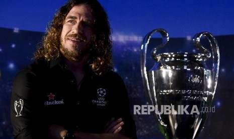 Pesepak bola legenda FC Barcelona Carles Puyol berpose di dekat trofi Liga Champion saat mengikuti UEFA Champions League Thropy Tour di Jakarta, Senin (11/3).