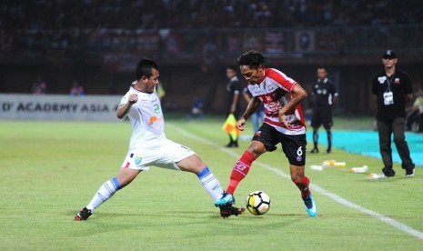 Pesepak bola Madura United (MU) Andik Rendika Rama (kanan) berusaha melewati pesepak bola Persela Lamongan Guntur A Riyadi (kiri) dalam kompetisi Liga 1 di Stadion Gelora Ratu Pamelingan (SGRP) Pamekasan, Jawa Timur, Sabtu (8/12/2018). 