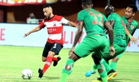 Pesepak bola Madura United (MU) Diego Assis (kanan) berusaha melewati pesepak bola Kalteng Rafael De Jesus (tengah) dalam laga Shopee Liga 1 di Stadion Gelora Madura Ratu Pamelingan (SGMRP) Pamekasan, Jawa Timur, Ahad (1/9).