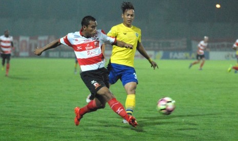 Pesepak bola Madura United (MU) Eriyanto (kiri) berusaha melewati pesepak bola Gresik United (GU) Jeki Arisandi, pada pertandingan Gojek Traveloka Liga 1, di Stadion Gelora Bangkalan (SGB) Bangkalan, Jatim, Kamis (1/6) malam. MU mengalahkan GU dengan skor 3-2. 