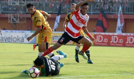 Pesepak bola Madura United (MU) FC Saldi (kanan) berebut bola dengan penjaga gawang Mitra Kukar Gerry Mandagi (bawah) pada laga Liga 1 di stadion Gelora Ratu Pamelingan (SGRP) Pamekasan, Jumat (28/4). 