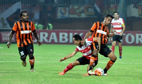 Pesepak bola Madura United (MU) FC Slamet Nurcahyo (kedua kiri) berebut bola dengan pesepak bola Perseru Serui Bryan Nus Muabuay saat babak penyisihan Grup E turnamen Piala Presiden di Stadion Gelora Ratu Pamelingan (SGRP), Pamekasan, Jawa Timur, Selasa (1