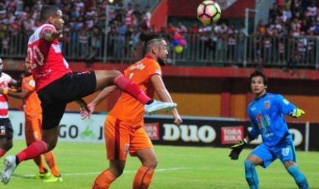 Pesepak bola Madura United (MU) Thiago Fortouso (kiri) berusaha menendang bola namun dihalangi pemain Pusamania Borneo FC (PBFC) Yamashita Kunohiro (tengah) dalam lanjutan kompetisi Gojek Traveloka Liga 1 di Stadion Gelora Ratu Pamelingan (SGRP) Pamekasan, Jawa Timur, Jumat (13/10) malam. Pertandingan berakhir imbang 1-1.