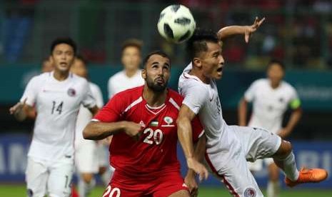 Pesepak bola Palestina Mohamed Darwish (kiri) berebut bola dengan pemain Hong Kong Yu Pui Hong (kanan) pada laga penyisihan Grup A cabang sepak bola Asian Games 2018 yang berlangsung di Stadion Patriot Bekasi Jawa Barat, Jumat (17/8/2018). 