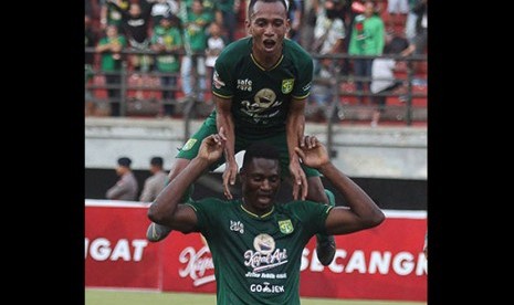 Penyerang Persebaya Amido Balde (bawah) dan Irfan Jaya.