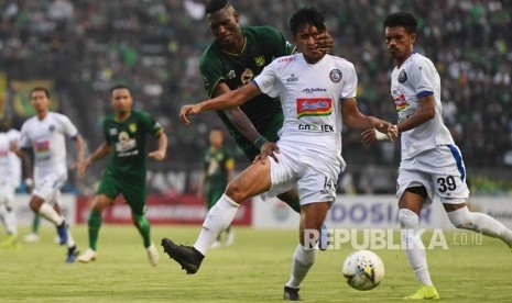 Pesepak bola Persebaya Surabaya Amido Balde (kiri) berusaha mereberebut bola pesepak bola Arema FC Jayus Hariono pada laga final leg 1 Piala Presiden 2019 di Gelora Bung Tomo, Surabaya, Jawa Timur, Selasa (9/4/2019).