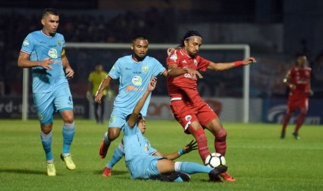 Pesepak bola Persela Lamongan Birrul Walidan (bawah) berebut bola dengan pesepak bola Persija Jakarta Rohit Chand (kanan) dalam lanjutan Liga 1 di Stadion Surajaya, Lamongan, Jawa Timur, Ahad (20/5). 