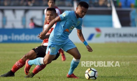 Pesepak bola Persela Lamongan Saddil Ramdani (kanan) melewati hadangan pesepak bola Madura United Asep Berlian (kiri) dalam lanjutan pertandingan Liga-1 di Stadion Surajaya Lamongan, Jawa Timur, Senin (23/7).