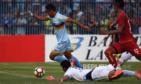 Pesepak bola Persela Lamongan Samsul Arif Munip (kiri) berusaha melewati hadangan penjaga gawang Arema Malang Kurnia Meiga Hermansyah (bawah) dalam pertandingan Gojek Traveloka Liga 1 di Stadion Surajaya Lamongan, Jawa Timur, MInggu (21/5). Persela Lamongan menang atas Arema Malang dengan skor 4-0. 