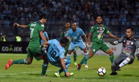 Pesepak bola Persela Lamongan Shohei Matsunaga (kedua kiri) berusaha menendang bola dengan dihadang penjaga gawang PSMS Medan Dhika Bayangkara (kanan) dalam lanjutan pertandingan Liga-1 Go-Jek di Stadion Surajaya Lamongan, Jawa Timur, Minggu (29/4). Persela Lamongan menang dengan skor 4-1. 