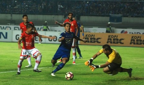 Pesepak bola Persib Bandung Achmad Jufriyanto (tengah) berusaha merebut bola dari penjaga gawang Persija Jakarta Andritany (kanan) pada laga lanjutan Liga 1 di Stadion Gelora Bandung Lautan Api (GBLA) Gedebage, Bandung, Jawa Barat, Sabtu (22/7). 