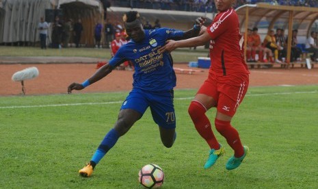 Pesepak bola Persib Bandung Ezechiel Ndouasel (kiri) berebut bola dengan pesepak bola Semen Padang FC Agung Prasetyo (kanan) pada laga lanjutan Liga 1 di Stadion Si Jalak Harupat Soreang, Kabupaten Bandung, Jawa Barat, Sabtu (9/9). 