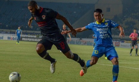 Gelandang Persib Bandung Febri Hariyadi (kanan) berebut bola dengan pemain Kalteng Putra Rafael Bonfim pada pertandingan lanjutan Liga 1 di Stadion Jalak Harupat, Kabupaten Bandung, Jawa Barat, Selasa (16/7).