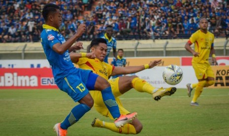 Pesepak bola Persib Bandung Febri Hariyadi (kiri) berusaha melewati pesepak bola Bhayangkara FC Jajang Mulyana (kedua kiri) pada pertandingan lanjutan Liga 1 di Stadion Jalak Harupat, Kabupaten Bandung, Jawa Barat, Ahad (30/6/2019). 