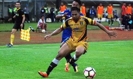 Pesepak bola Persib Bandung Febri Hariyadi (kiri) dihalau pesepak bola Mitra Kukar FC Saepuloh Maulana (kanan) pada laga lanjutan GO-JEK Traveloka Liga 1 di Stadion Si Jalak Harupat Soreang, Kabupaten Bandung, Jawa Barat, Jumat (27/10).