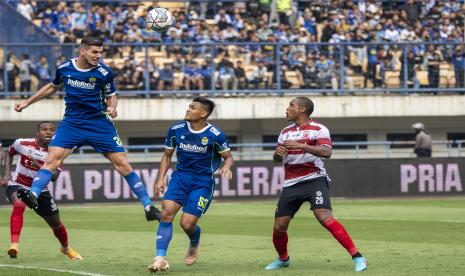 Pesepak bola Persib Bandung Nick Kuipers (kedua kiri) menyundul bola dibayangi Rachmat Irianto (kedua kiri) dan pesepak bola Madura United Pedro H (kanan) saat pertandingan BRI Liga 1 di Stadion Gelora Bandung Lautan Api, Bandung, Jawa Barat, Sabtu (30/7/2022). 