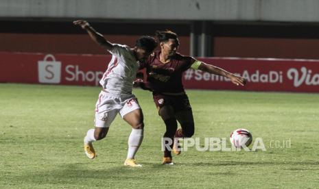 Pesepak bola Persija Jakarta Heri Susanto (kiri) berebut bola dengan pesepak bola PSM Makassar Zulkifli Syukur (kanan) saat pertandingan semifinal Piala Menpora 2021 di Stadion Maguwoharjo, Sleman, DI Yogyakarta, Kamis (15/4/2021).