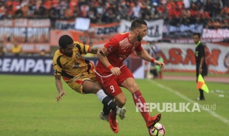 Pesepak bola Persija Jakarta, Marko Simic (kanan) dihadang pesepak bola Mitra Kukar FC, Abdul Gamal (kiri) pada pertandingan delapan besar Piala Presiden di Stadion Manahan Solo, Jawa Tengah, Ahad (4/2).