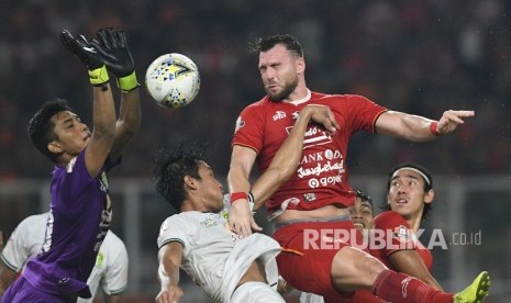 Pesepak bola Persija Jakarta Marko Simic (kedua kanan) berusaha menyundul bola dengan dihadang penjaga gawang Persebaya Surabaya Miswar Saputra (kiri) dalam lanjutan Liga-1 Indonesia di Stadion Utama Gelora Bung Karno (GBK), Jakarta, Selasa (17/12/2019).