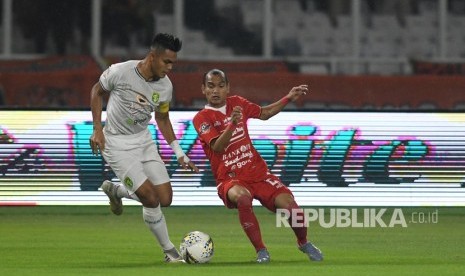 Pesepak bola Persija Jakarta Riko Simanjuntak (kanan) berusaha melewati adangan pesepak bola Persebaya Surabaya Rachmat Irianto (kiri) dalam lanjutan Liga-1 Indonesia di Stadion Utama Gelora Bung Karno (GBK), Jakarta, akhir tahun lalu. 