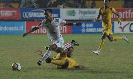 Pesepak bola Persija Jakarta Riko Simanjuntak (kiri) berebut bola dengan pesepak bola Sriwijaya FC Hamka Hamzah (bawah) pada pertandingan Liga 1 di Stadion Gelora Sriwijaya Jakabaring Palembang, Sumatera Selatan, Selasa (10/7). Sriwijaya FC bermain imbang bersama Persija dengan skor 2-2.