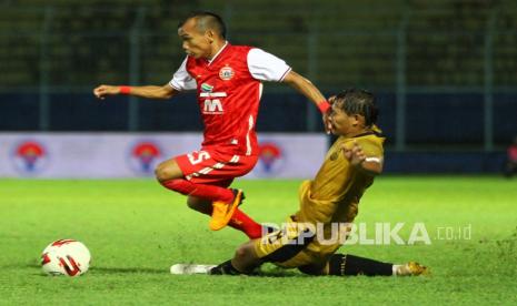 Pesepak bola Persija Jakarta Riko Simanjuntak (kiri) berusaha melewati hadangan pesepak bola Bhayangkara Solo FC Mohammad Hargiyanto (kanan) dalam laga lanjutan Piala Menpora Grup B di Stadion Kanjuruhan, Malang, Jawa Timur, Rabu (31/3/2021). Persija Jakarta melaju ke babak delapan besar setelah mengalahkan Bhayangkara Solo FC dengan skor akhir 2-1.