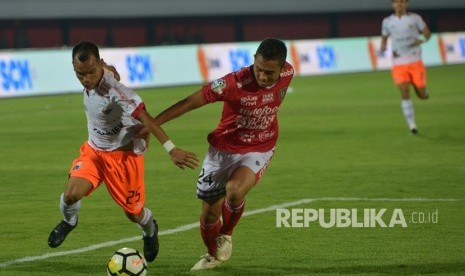 Pesepak bola Persija Riko Simanjuntak (kiri) berebut bola dengan pemain Bali United Ricky Fajrin pada pertandingan Sepak Bola Liga 1 di Stadion I Wayan Dipta, Gianyar, Bali, Ahad (02/12/2018). 