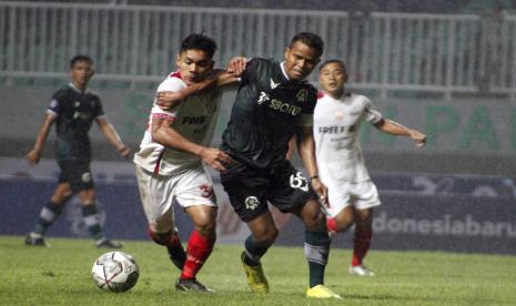 Pesepak bola Persikabo 1973 Manahati Lestusen (kanan) berebut bola dengan pesepak bola Persis Solo Althaf Indi Alrizky (kiri) pada lanjutan BRI Liga 1 di Stadion Pakansari, Kabupaten Bogor, Jawa Barat, Ahad (7/8/2022). Persikabo 1973 menang dengan skor 2-0. 