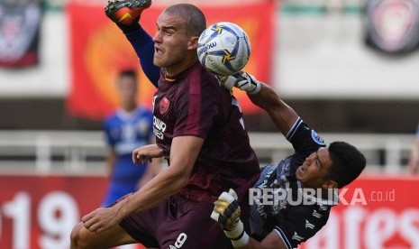 Pesepak bola PSM Makassar Eero Markkanen (kiri) berebut bola dengan kiper Becamex Binh Duong asal Vietnam Tran Duc Cuong pada semi final leg kedua Piala AFC 2019 zona Asean di Stadion Pakansari, Bogor, Jawa Barat, Rabu (26/6/2019). 