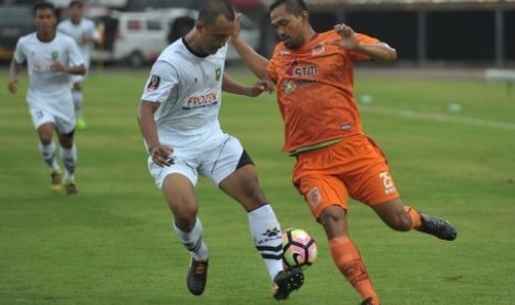 Pesepak bola PSPS RIau Wahyu Kristanto (tengah) berebut bola dengan pesepak bola Borneo FC Febri Setiadi Hamzah (kanan) dalam pertandingan babak penyisihan Grup D Piala Presiden 2018 di Stadion I Wayan Dipta, Gianyar, Bali, Senin (29/1). Borneo FC menang dengan skor 3-0. 