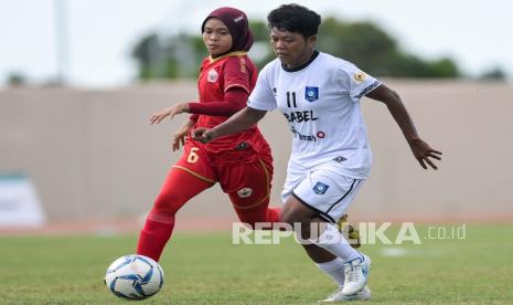 Pesepak bola putri Babel Susilawati (kanan) berebut bola dengan pesepak bola putri DKI Jakarta Sri Devi (kiri) saat bertanding pada final Sepak Bola Putri PON Papua di Stadion Katalpal, Kabupaten Merauke, Papua, Senin (11/10/2021). Tim sepak bola putri Bangka Belitung (Babel) berhasil meraih medali perunggu setelah menang atas tim sepak bola putri DKI Jakarta dengan skor 3-0. 