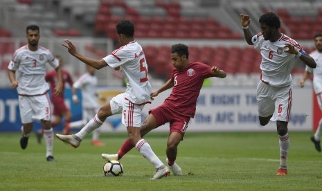 Pesepak Bola Qatar Hashim Ali (kedua kanan) berusaha melewati hadangan tiga pesepak bola Uni Emirat Arab (UEA) dalam laga Grup A Piala Asia U-19 di Stadion Utama Gelora Bung Karno, Jakarta, Kamis (18/10/2018).