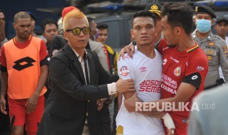 Pesepak bola Semen Padang FC, Muhammad Rifqi (kanan) berusaha menenangkan pemain PSM Makassar, Ferdinand Sinaga (tengah) akibat insiden cederanya kiper Rivky Mokodompit, pada pertandingan lanjutan putaran kedua, Liga 1, di Stadion GOR H Agus Salim Padang, Sumatera Barat, Senin (23/9/2019). 