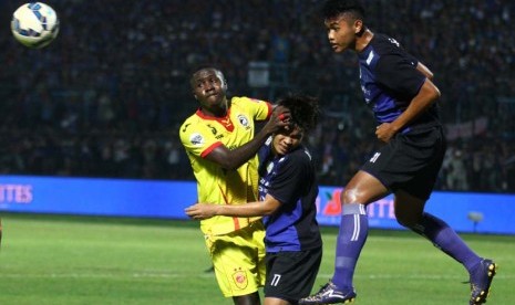 Pesepak bola Sriwijaya FC, A. Maiga (kiri), berebut bola dengan pesepakbola Arema Cronus, Juanda Irawan (kanan) dan Benny wahyudi (tengah), dalam pertandingan Piala Jenderal Sudirman Grup A di Stadion Kanjuruhan, Malang, Jawa Timur, Ahad (22/11). 