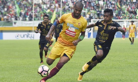 Pesepak bola Sriwijaya FC Hilton Moreira (kiri) berebut bola dengan pesepak bola Borneo FC Ricky Akbar Ohorella (kanan) dalam pertandingan Gojek Traveloka Liga 1 di Stadion Gelora Sriwijaya Jakabaring (GSJ), Jakabaring Sport City (JSC), Palembang, Sumatera Selatan, Sabtu (22/4).