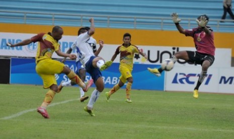 Pesepak bola Sriwijaya FC Lancine Kone (kiri) melancarkan tendangan ke arah Penjaga Gawang Barito Dedi Iman (kanan) pada Laga ISL di Stadion Gelora Sriwijaya Jakabaring, Palembang, Sumsel, Minggu ((4/5). Sriwijaya FC berhasil mengalahkan Barito Putera deng