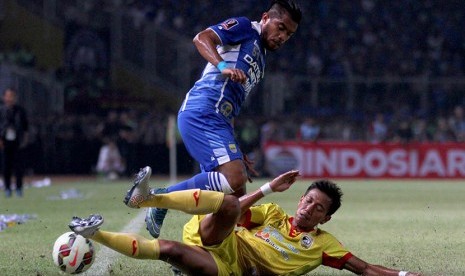 Pesepak bola Sriwijaya FC Saiful Indra (bawah) menjegal pesepak bola Persib Bandung Zulham Zamrun (atas) saat laga final Piala Presiden di Stadion Utama Gelora Bung Karno, Senayan, Jakarta, Ahad (18/10)