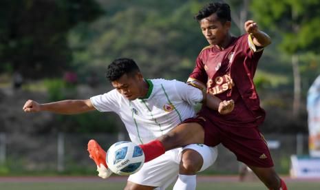 Pesepak bola Sumatera Utara Rio Syahputra (kiri) berebut bola dengan pesepak bola Sulawesi Selatan Anugerah (kanan) saat bertanding pada penyisihan grup B Sepak Bola PON Papua di Stadion Mahacandra, Kota Jayapura, Papua, Kamis (30/9/2021). Sumut menang atas Sulsel dengan skor 1-0.