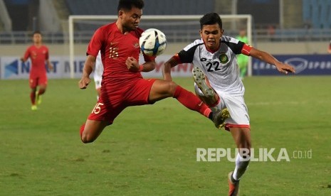 Pesepak bola tim nasional Indonesia U-23 Saddil Ramdani (kiri) berebut bola dengan pesepak bola tim nasional Brunei Darussalam U-23 Muhammad Hanif Hamir (kanan) pada pertandingan Grup K kualifikasi Piala Asia U-23 AFC 2020 di Stadion Nasional My Dinh, Hanoi, Vietnam, Selasa (25/3/2019). 