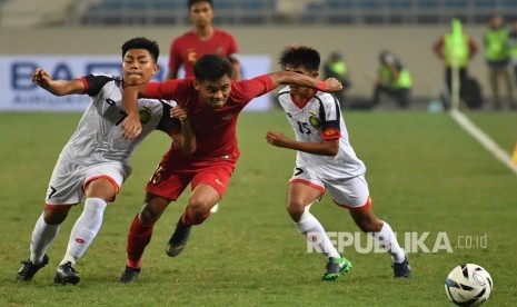 Pesepak bola tim nasional Indonesia U-23 Saddil Ramdani (tengah) berupaya meloloskan diri dari kawalan dua pesepak bola tim nasional Brunei Darussalam U-23 Muhammad Nur (kiri) dan Rahmin Abdul Ghani (kanan), pada pertandingan Grup K kualifikasi Piala Asia U-23 AFC 2020 di Stadion Nasional My Dinh, Hanoi, Vietnam, Selasa (26/3/2019). 