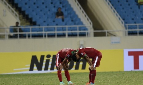 Pesepak bola timnas Indonesia Achmad Jufriyanto dan Muhammad Roby tertunduk seusai dikalahkan Filipina pada pertandingan penyisihan Piala AFF 2014 Grup A di Stadion My Dinh, Hanoi, Selasa (25/11).