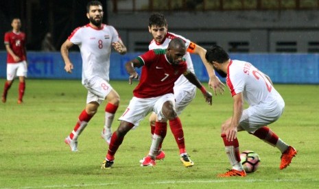 Pesepak bola Timnas Indonesia Boaz Salossa (tengah) berebut bola dengan pesepak bola Timnas U-23 Suriah Ahmad Alghalab (kanan) pada pertandingan laga persahabatan Timnas Indonesia melawan Timnas U-23 Suriah, di Stadion Wibawa Mukti, Cikarang, Jawa Barat, Sabtu (18/11). 