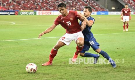 Pesepak bola Timnas Indonesia Fachruddin Aryanto (kiri) berebut bola dengan pesepak bola Timnas Thailand Chanatip Songkrasin (kanan) dalam pertandingan Babak Final Leg 1 Piala AFF 2020 di National Stadium, Singapura, Rabu (29/12/2021). Thailand mengalahkan Indonesia dengan skor 4-0.