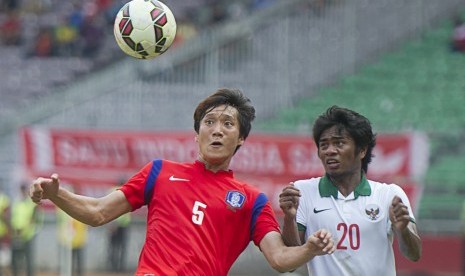 Pesepak bola Timnas Indonesia Ilham Udin Armaiyn (kanan) berebut bola dengan pesepak bola Timnas Korsel Woo Jusung pada pertandingan kualifikasi Grup H Kejuaraan Piala Asia (AFC) U-23 Tahun 2016 di Stadion Utama Gelora Bung Karno, Senayan, Jakarta, Selasa 