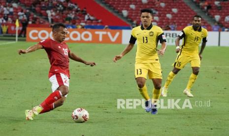 Pesepak bola Timnas Indonesia Irfan Jaya (kiri) berusaha melewati pesepak bola Timnas Malaysia Arif Aiman (tengah) dalam pertandingan grup B Piala AFF 2020 di National Stadium, Singapura, Ahad (19/12/2021). Indonesia menang dengan skor 4-1 dan lolos ke babak semi final Piala AFF. 