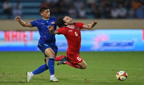 Pesepak bola Timnas Indonesia Marc Klok (kanan) terjatuh karena dilanggar pesepak bola Timnas Thailand Anusak Jaiphet (kiri) pada pertandingan semifinal sepak bola SEA Games 2021 Vietnam di Stadion Thien Truong, Nam Dinh, Vietnam, Kamis (19/5/2022). Indonesia kalah dari Thailand dengan skor 0-1 dan gagal melaju ke final. Klok merupakan satu dari tiga pemain Persib yang memperkuat timnas.