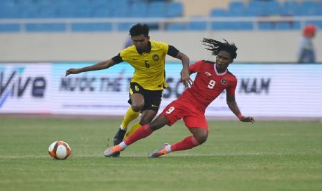 Pesepak bola Timnas Indonesia Ronaldo Kwateh (kanan) berebut bola dengan pesepak bola Timnas Malaysia Muhammad Azam (kiri) dalam laga perebutan medali perunggu sepak bola SEA Games 2021 Vietnam di Stadion Nasional My Dinh, Hanoi, Vietnam, Minggu (22/5/2022).